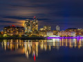 The moon hidden behind high-rises on a calm night in Victoria BC's Inner Harbour